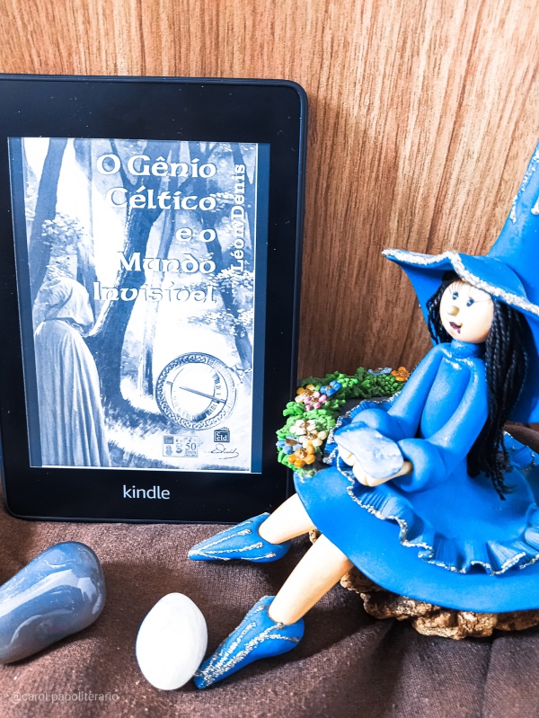 Capa do livro O Gênio Céltico e o Mundo Invisível na versão eBook, no Kindle, ao lado de uma boneca representando Morgana e alguns cristais.