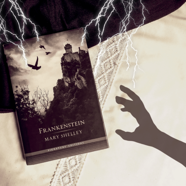 Livro Frankenstein na metade esquerda da foto, com a sombra de uma mão tentando alcançar e pegar o livro, entrando pela direita da foto. Há raios caindo sobre o livro, vindo da parte superior da foto.