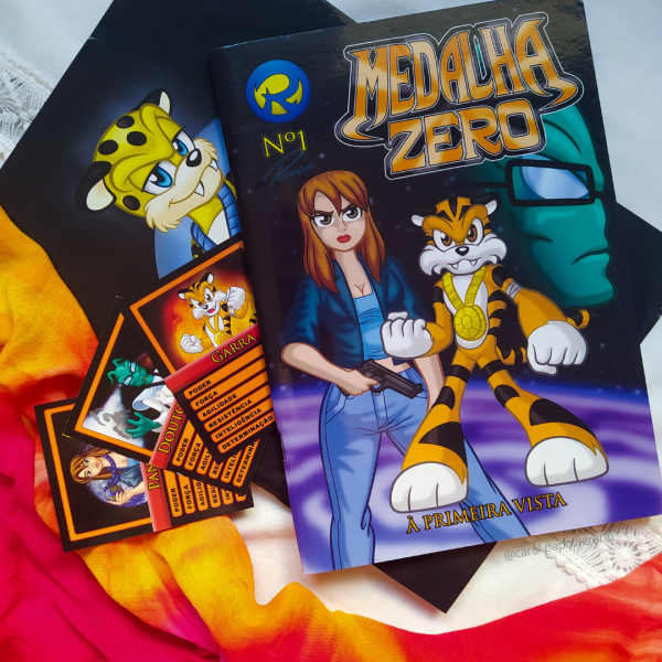 Revista Medalha Zero número 1, com um pôster do personagem da HQ, Pintado, abaixo da revistinha, e 3 cards colecionáveis dos personagens Pandora, Doutor Mente e Garra ao lado da revistinha.
