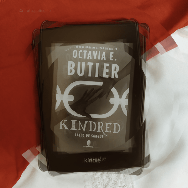 Kindle com a capa do livro Kindred, aplicado efeito como se estivesse desintegrando em círculos.